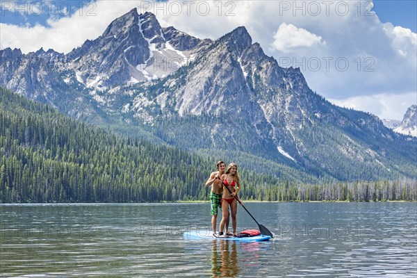 Caucasian couple on paddleboard in lake