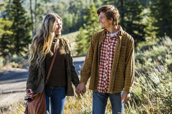 Smiling Caucasian couple holding hands outdoors