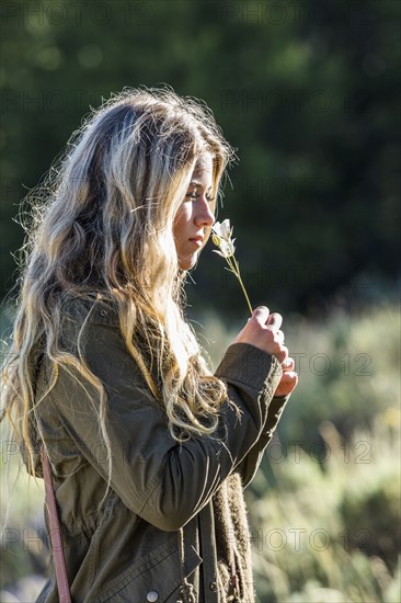 Caucasian girl smelling wildflower