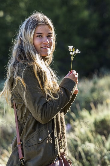 Portrait of smiling Caucasian girl holding wildflower