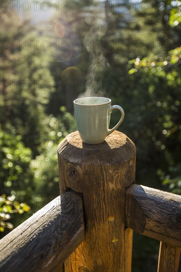 Steaming coffee cup on wooden post
