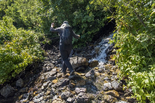 Caucasian woman hiking on rocks in river