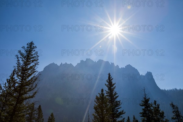 Sunbeams over trees near mountain