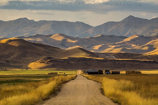 Dirt road to farm and mountains