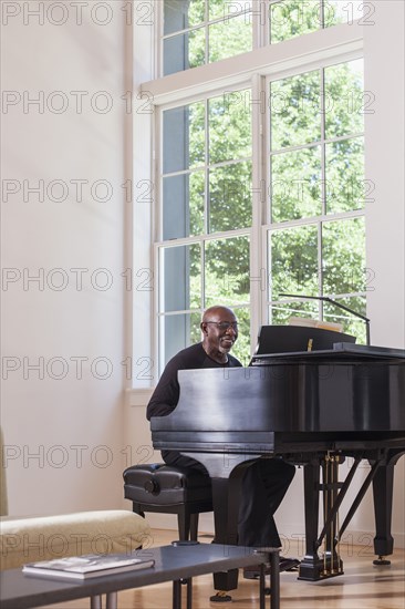 Man playing piano near window