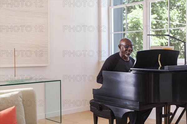 Man playing piano near window