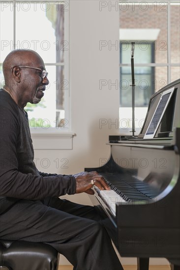 Man playing piano near window