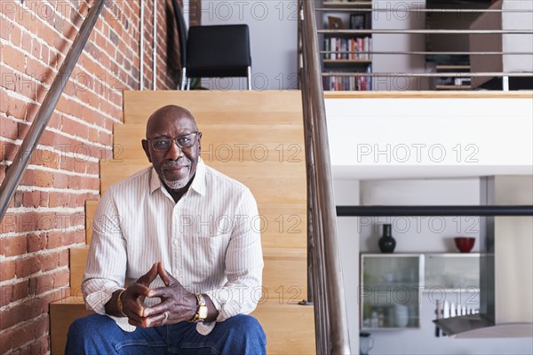 Smiling man sitting on staircase