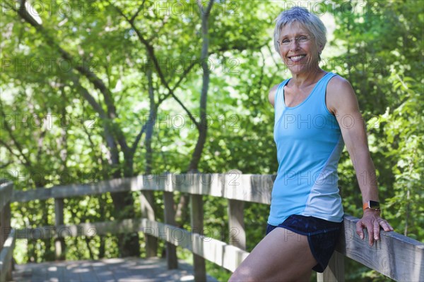 Caucasian woman leaning on wooden fence