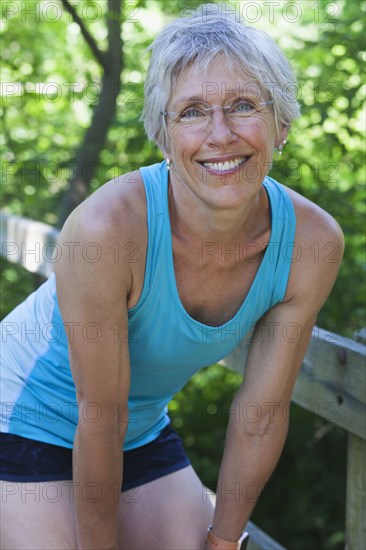 Caucasian woman resting wooden fence