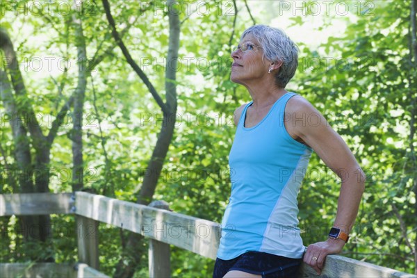 Caucasian woman leaning on wooden fence looking up