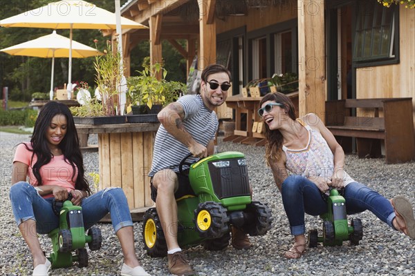 Friends playing on toy tractors