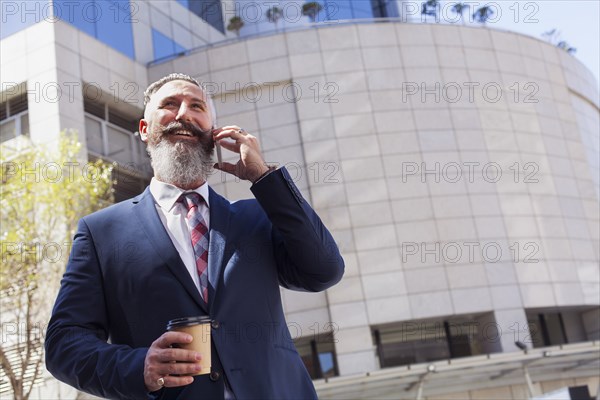 Caucasian businessman talking on cell phone outdoors