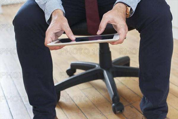 Caucasian businessman sitting on chair using digital tablet