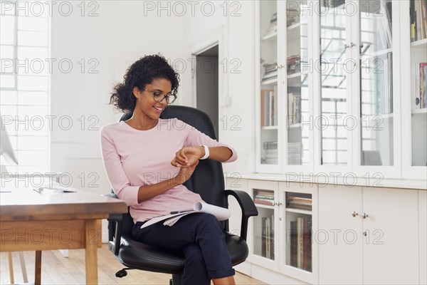 Mixed Race woman checking wristwatch