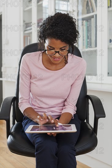 Mixed Race woman using digital tablet