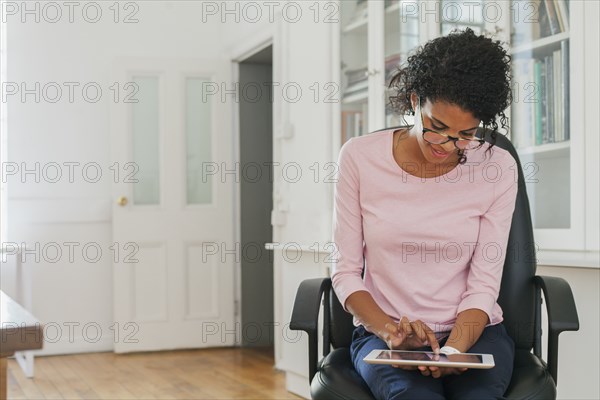 Mixed Race woman using digital tablet