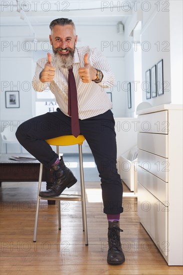 Portrait of smiling Caucasian businessman gesturing thumbs up