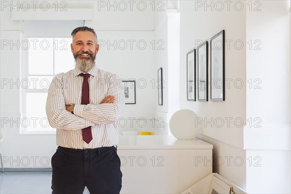 Portrait of smiling Caucasian businessman with arms crossed