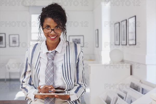 Smiling Mixed Race woman using digital tablet