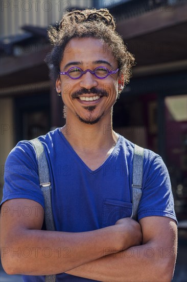 Smiling mixed race man wearing suspenders