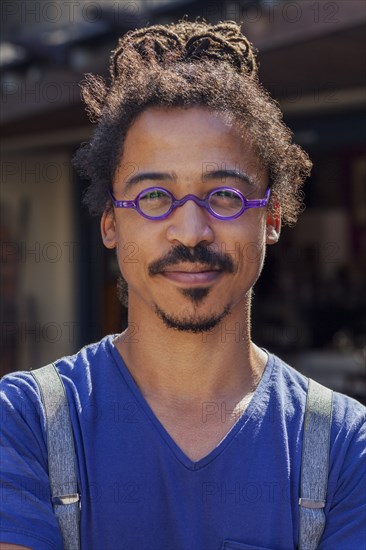 Serious mixed race man wearing suspenders