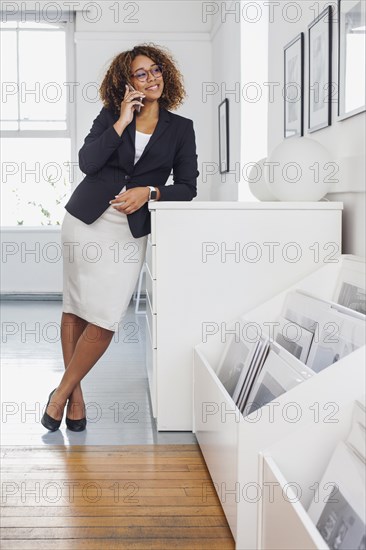 Mixed race woman talking on cell phone in gallery