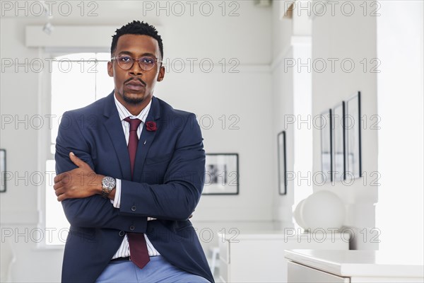 Black man with arms crossed in gallery