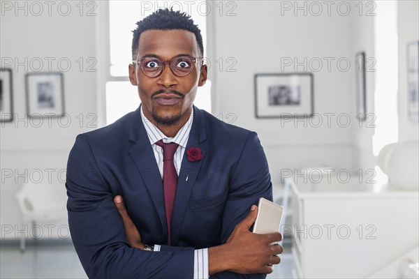 Black man with arms crossed in gallery