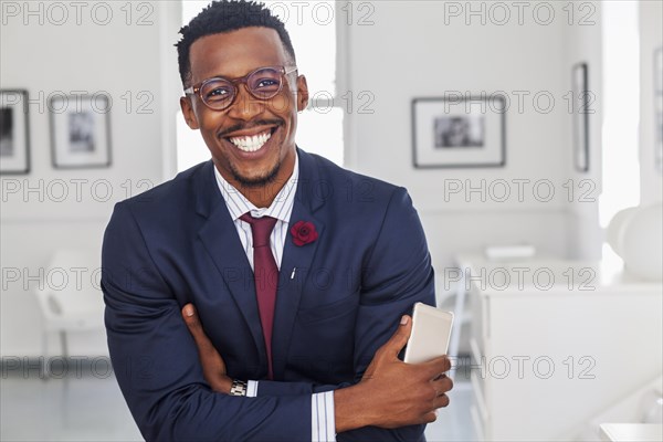 Black man with arms crossed in gallery