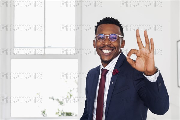 Black man gesturing okay in gallery