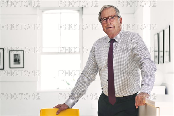 Smiling Caucasian businessman leaning on chair