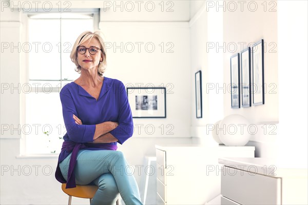 Confident Caucasian woman sitting on stool