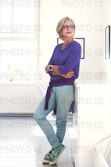 Confident Caucasian woman leaning on cabinet