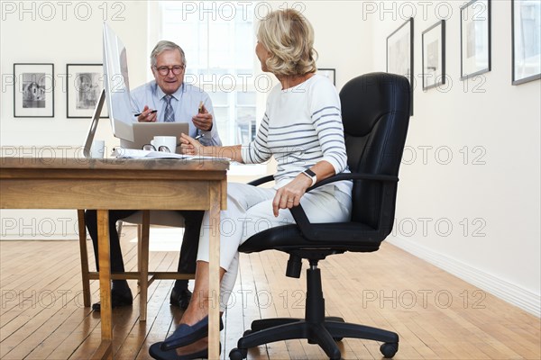 Caucasian businessman and businesswoman talking at table