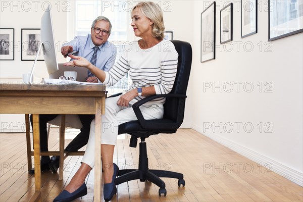 Caucasian businessman and businesswoman using computer