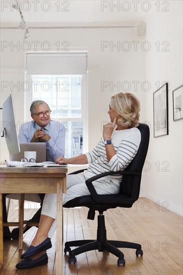 Caucasian businessman and businesswoman talking at table