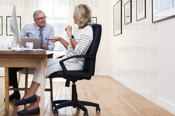 Caucasian businessman and businesswoman talking at table