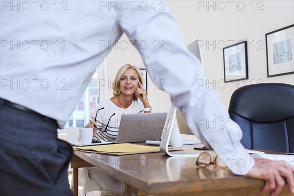 Caucasian businessman and businesswoman talking at table