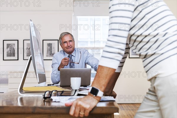 Caucasian businessman and businesswoman talking at table