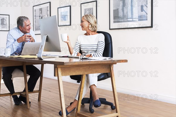 Caucasian businessman and businesswoman talking at table