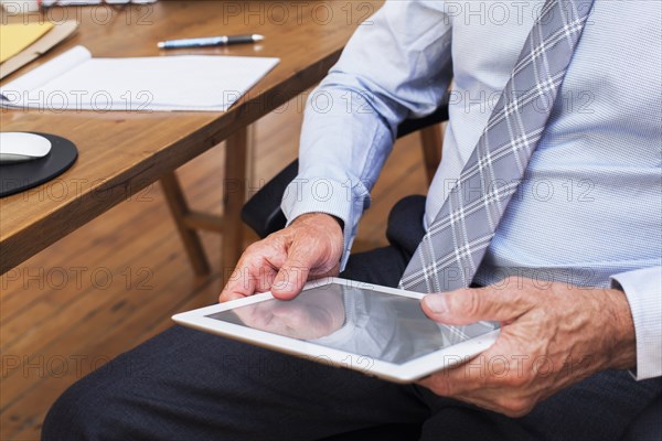 Hands of Caucasian businessman holding digital tablet