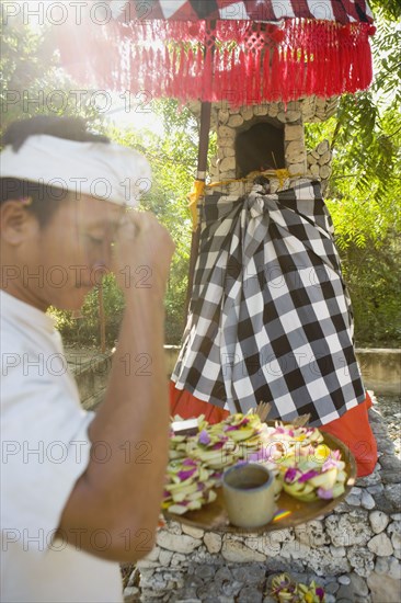 Asian man holding tray of flower petals