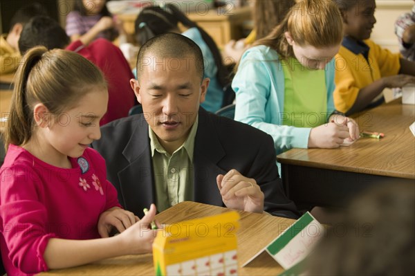 Asian school teacher helping students