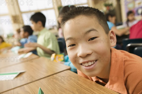 Asian school boy sitting at desk