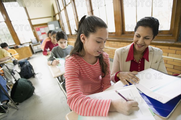 Hispanic school teacher helping student