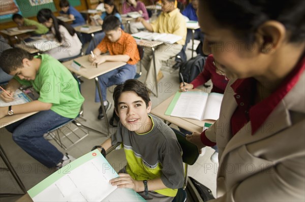 Hispanic school teacher helping student