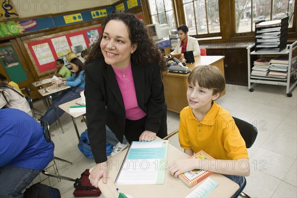 Hispanic school teacher helping student