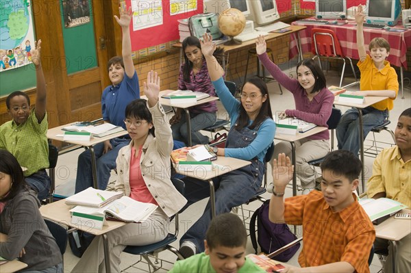 Students raising hands in classroom