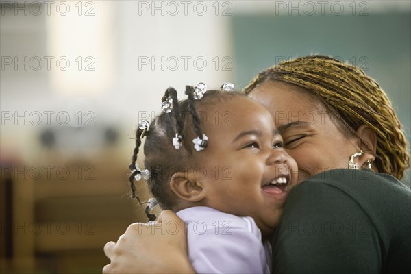 African woman hugging daughter